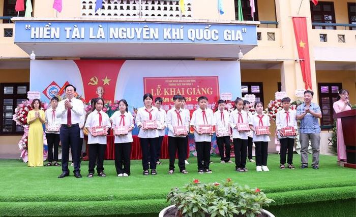 Chủ tịch UBND xã Tam Hưng Bùi Đình Thái và các đơn vị đồng hành trao tặng những phần quà động viên học sinh có hoàn cảnh khó khăn. Ảnh: Bình Minh