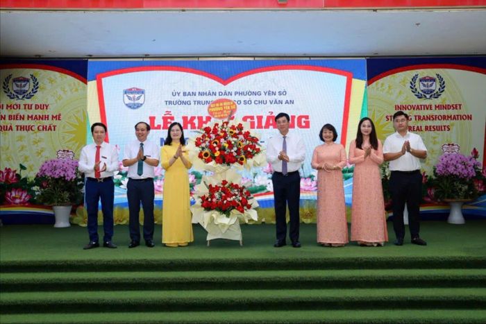 Bí thư Đảng ủy phường Yên Sở Nguyễn Minh Tâm cùng lãnh đạo phường tặng hoa chúc mừng thầy, trò Trường THCS Chu Văn An. Ảnh: Thái Phương