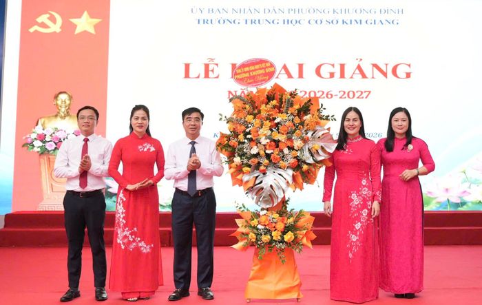 Bí thư Đảng ủy, Chủ tịch HĐND phường Khương Đình Võ Đăng Dũng tặng hoa chúc mừng cán bộ, giáo viên, nhân viên và học sinh Trường THCS Kim Giang bước vào năm học mới. Ảnh: KĐ