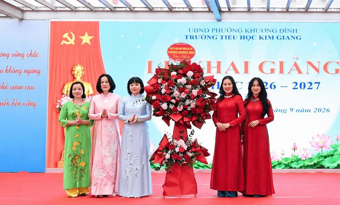 Phó Bí thư Thường trực Đảng ủy phường Khương Đình Trần Thị Nga tặng hoa chúc mừng cán bộ, giáo viên, nhân viên và học sinh Trường Tiểu học Kim Giang. Ảnh: KĐ