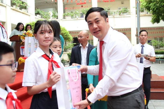 Chủ tịch UBND phường Cầu Giấy Ngô Ngọc Phương tặng quà cho các em học sinh trường THCS Cầu Giấy A nhân dịp bước vào năm học mới. Ảnh: Vân Nhi