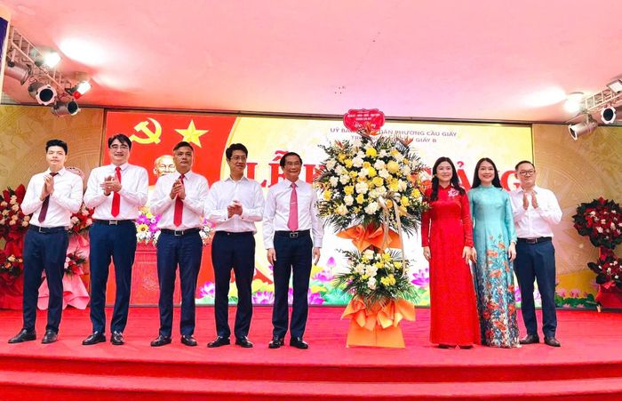 Phó Bí thư Thường trực Đảng uỷ phường Cầu Giấy Phạm Ngọc Anh tặng hoa chúc mừng trường THCS Cầu Giấy B. Ảnh: Vân Nhi