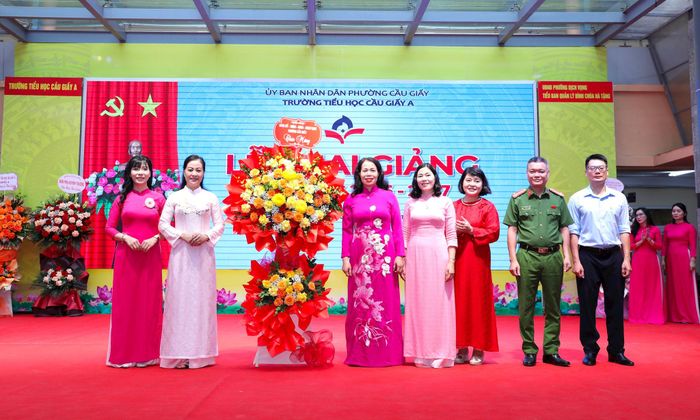 Đồng chí Nguyễn Thị Liễu, Bí thư Đảng uỷ phường Cầu Giấy tặng hoa chúc mừng trường Tiểu học Cầu Giấy A nhân dịp khai giảng năm học mới. Ảnh: Vân Nhi