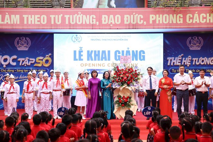 Lãnh đạo phường Đại Mỗ tặng hoa, chúc mừng thầy và trò Trường TH & THCS Nguyễn Du. Ảnh: PV