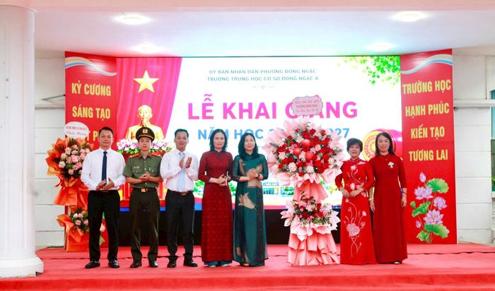 Bí thư Đảng uỷ phường Đông Ngạc Đặng Hương Giang và các đồng chí lãnh đạo ban ngành, đoàn thể phường tặng hoa chúc mừng thầy cô trường THCS Đông Ngạc A. Ảnh: Hồng Nhung