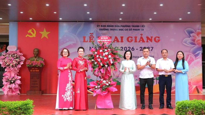 Lãnh đạo Phường Thanh Liệt tặng hoa chúc mừng thầy cô và học sinh Trường THCS Phạm Tu. Ảnh: PV