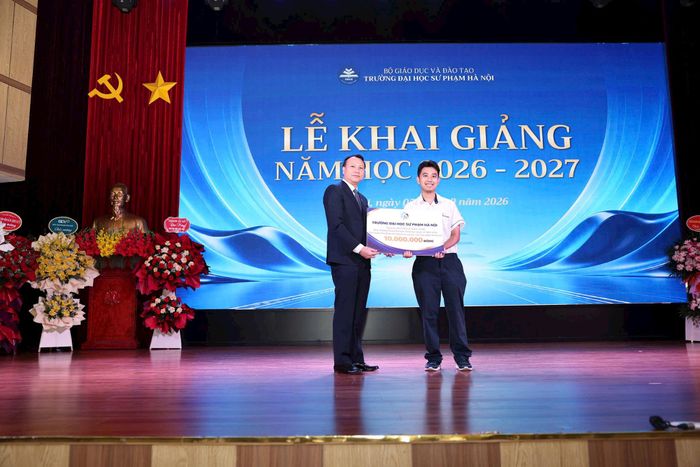 Phó Giáo sư, Tiến sĩ Nguyễn Đức Sơn, Hiệu trưởng nhà trường trao thưởng cho tân sinh viên Nguyễn Lê Nhật Nam đạt Huy chương vàng IMO 2026. Ảnh: Thanh Tùng