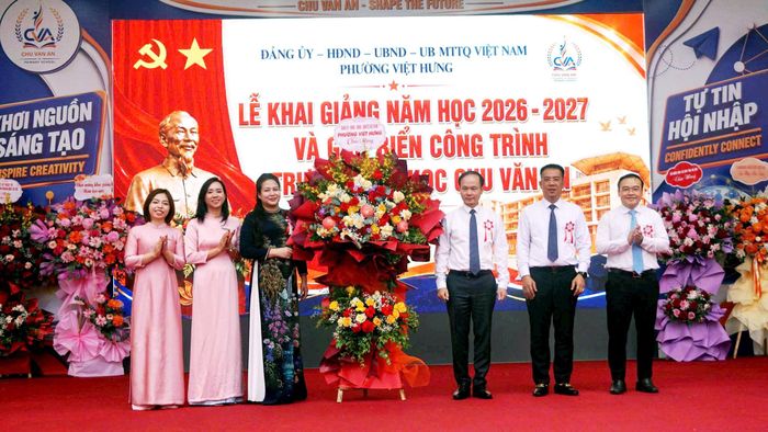 Lãnh đạo phường Việt Hưng tặng hoa chúc mừng Ban Giám hiệu trường Tiểu học Chu Văn An. Ảnh: B.Duy