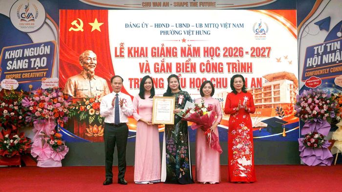 Lãnh đạo Sở Giáo dục và Đào tạo thành phố Hà Nội và phường Việt Hưng trao Chứng nhận công trình, tặng hoa chúc mừng Ban Giám hiệu Trường Tiểu học chất lượng cao Chu Văn An. Ảnh: B.Duy