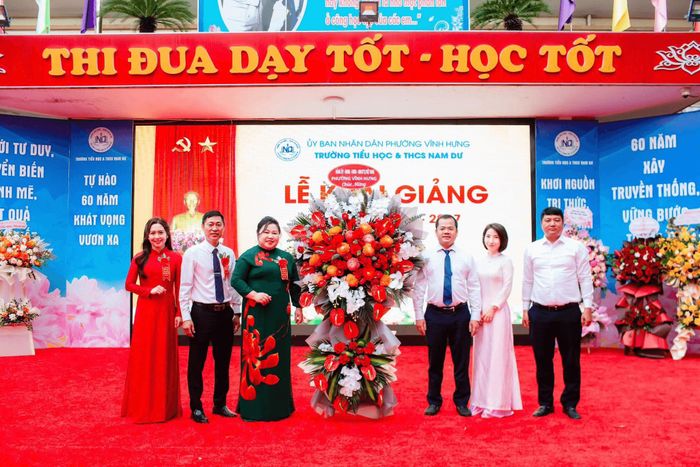 Lãnh đạo phường Vĩnh Hưng tặng hoa, chúc mừng thầy và trò Trường tiểu học và THCS Nam Dư. Ảnh: PV