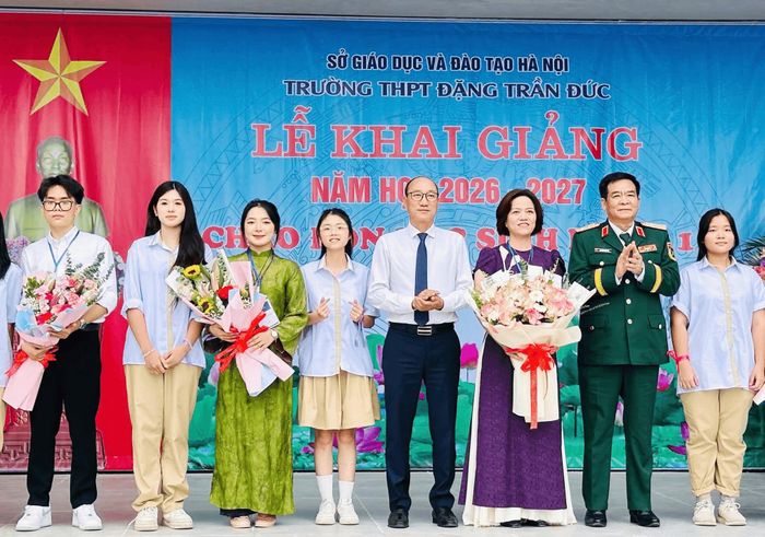 Chủ tịch UBND phường Vĩnh Hưng Phạm Hải Bình tặng hoa, chúc mừng thầy và trò Trường THPT Đặng Trần Đức. Ảnh: PV