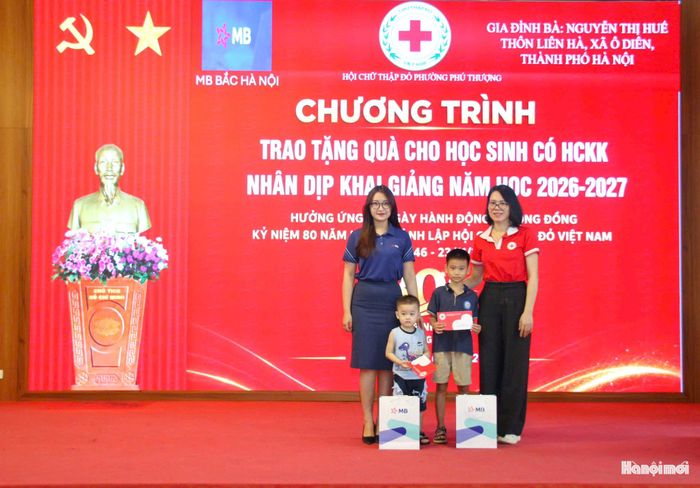 Bà Đỗ Thị Kim Ngân, Chủ tịch Hội Chữ thập đỏ phường Phú Thượng cùng đại diện nhà tài trợ trao quà tặng học sinh có hoàn cảnh khó khăn trước thềm năm học mới. Ảnh: Cao Kỳ