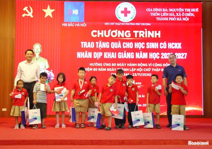 Đồng chí Trần Quang Đạo, Phó Bí thư Thường trực Đảng ủy phường Phú Thượng cùng đại diện nhà tài trợ trao quà tặng học sinh có hoàn cảnh khó khăn nhân dịp bước vào năm học mới. Ảnh: Cao Kỳ