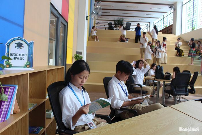 Học sinh Nguyễn Ngân Hà (trái) và Đinh Xuân Tiến (phải) đọc sách tại thư viện. Ảnh: Vi Giáng