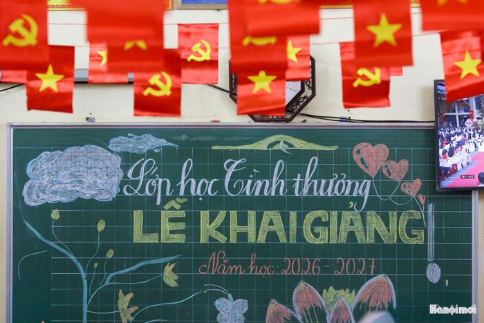 Bên trong căn phòng học nhỏ được trang trí trang trọng, ấm cúng để chuẩn bị cho giờ phút khai giảng năm học 2026 - 2027. Những dãy bàn ghế ngay ngắn, chiếc bảng xanh được các cô giáo trang trí giản dị bằng phấn màu, góc tường treo rực rỡ lá cờ Tổ quốc cùng những bức tranh do chính tay các học sinh vẽ. Mọi thứ đã sẵn sàng cho một buổi lễ khai giảng mộc mạc nhưng đong đầy ý nghĩa.