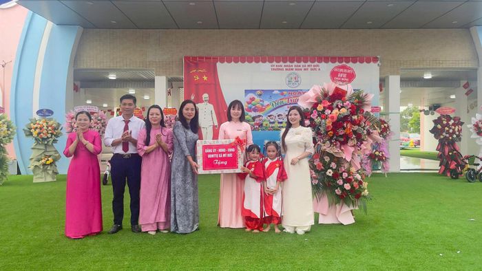 Đồng chí Nguyễn Thị Thúy Hòa, Phó Bí thư Thường trực Đảng ủy xã Mỹ Đức (thứ tư từ trái qua) tặng quà cô trò Trường Mầm non Mỹ Đức A. Ảnh: Văn Biên