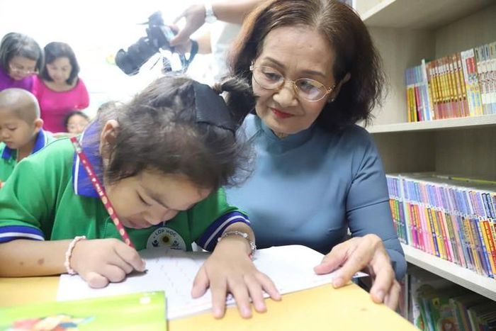 Cô giáo Nguyễn Thị Kim Xoàn, 72 tuổi, hướng dẫn các em học sinh viết chữ. Ảnh: Nam Thương
