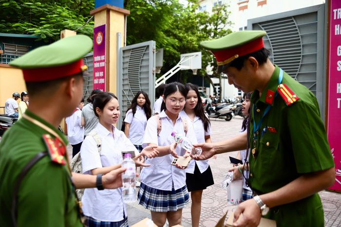Tại Trường Trung học cơ sở Ba Đình trên phố Nguyễn Trường Tộ, bên cạnh nhiệm vụ bảo đảm trật tự, an toàn giao thông, Công an phường Ba Đình tổ chức phát nước miễn phí cho học sinh và phụ huynh. (Ảnh Thành Long)