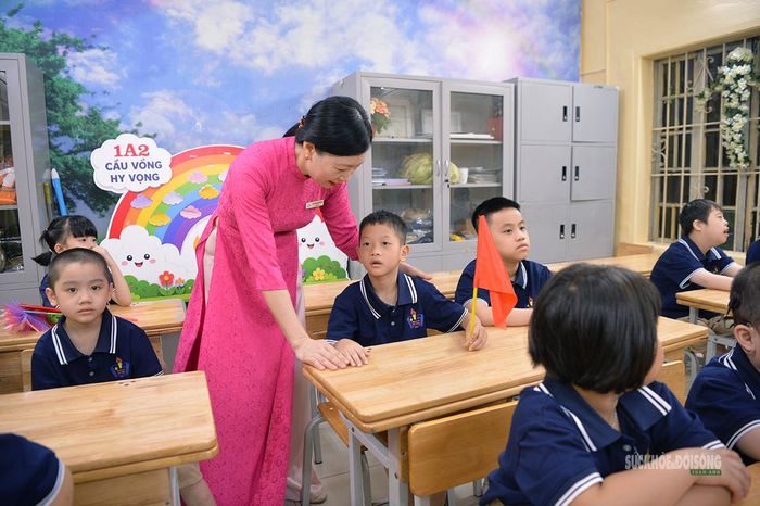 Giáo viên hướng dẫn học sinh nhỏ làm quen với lớp học. Ảnh: Tuấn Anh