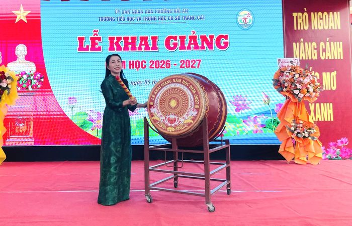 Cô Bùi Thị Hiên - Hiệu trưởng Trường TH và THCS Tràng Cát đánh trống khai trường. Ảnh: T.Dung.