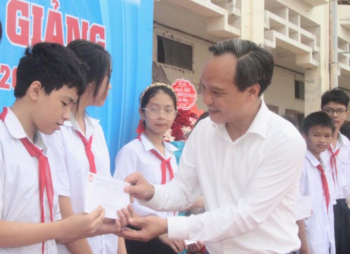 Lãnh đạo Đảng ủy xã Vĩnh Lại tặng hoa chúc mừng Trường Mầm non Ứng Hòe (ảnh trên) và tặng quà cho những học sinh có hoàn cảnh khó khăn Trường THCS Vĩnh Lại (ảnh dưới). Ảnh: Đ.Tùy.