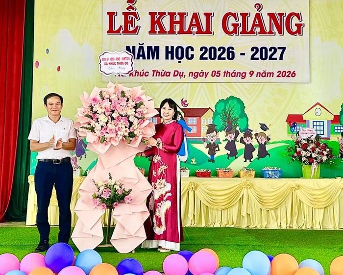 Cô Trịnh Thị Nếp - Hiệu trưởng Trường Mầm non Khúc Hạo nhận hoa chúc mừng từ lãnh đạo xã Khúc Thừa Dụ. Ảnh: Đ.Tùy