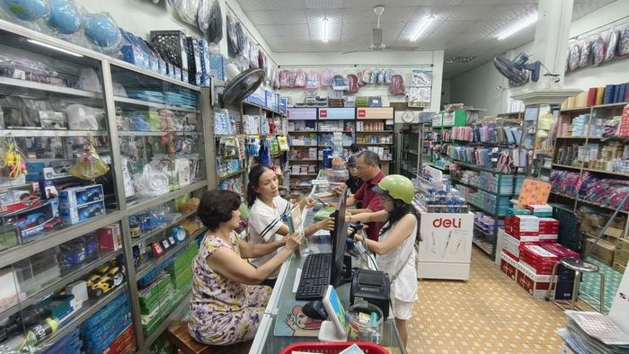 Nhiều phụ huynh phải đi săn lùng sách giáo khoa tại một số hiệu sách. Ảnh: Sỹ Thắng - TTXVN