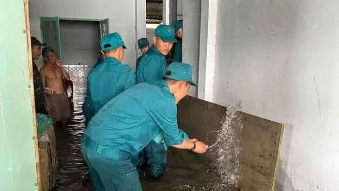 Lực lượng Dân quân xã Thiện Hưng giúp nhân dân di chuyển vật dụng gia đình tránh ngập (Ảnh: CTV)