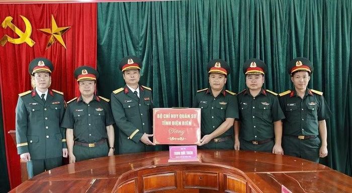 Đại tá Trịnh Đức Thiêm động viên và tặng quà Ban Chỉ huy Quân sự xã Sín Thầu. (Ảnh: LÊ LAN-THÀNH HẠNH)