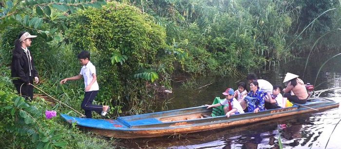  Học sinh ở lâm phần rừng tràm U Minh Hạ, xã Khánh Lâm, tỉnh Cà Mau được phụ huynh đưa đi dự khai giảng bằng vỏ lãi 