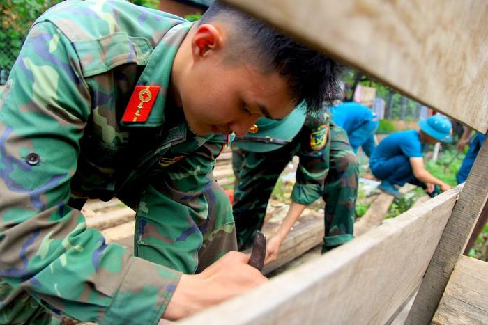 Các chiến sĩ trẻ rất hăng hái, phấn khởi khi được giúp bà con từ vùng thiên tai đến nơi ở mới an toàn, khang trang hơn.