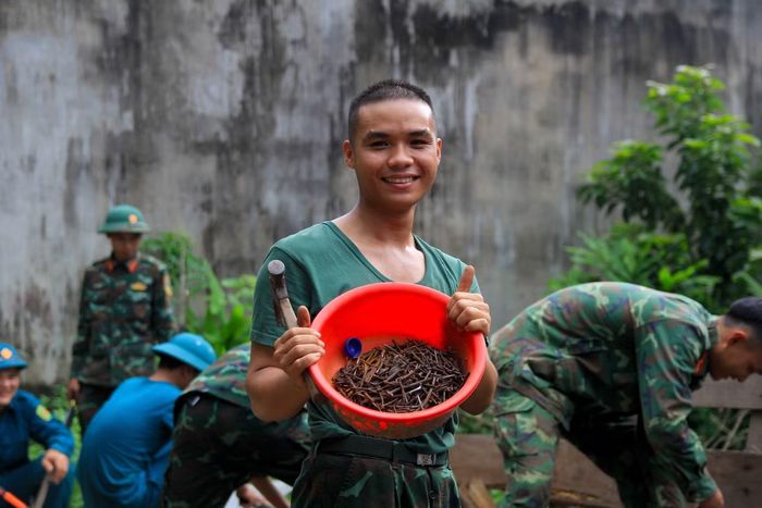 Các chiến sĩ trẻ nhổ đinh, phân loại gỗ còn sử dụng được.