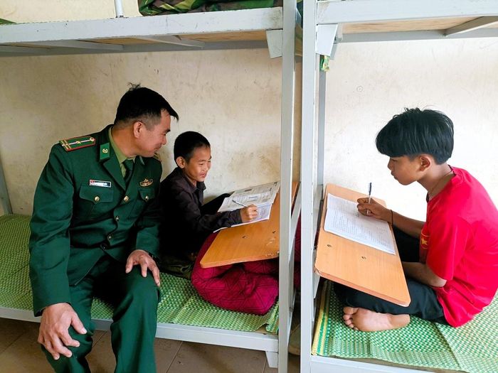 Cán bộ Đồn Biên phòng Môn Sơn hỗ trợ, hướng dẫn học sinh tại ký túc xá làm bài tập ngoài giờ