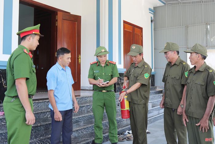 Ông Dương Kim Thích (người thứ 2 từ trái sang) được thành viên đội dân phòng hướng dẫn cách sử dụng bình chữa cháy.
