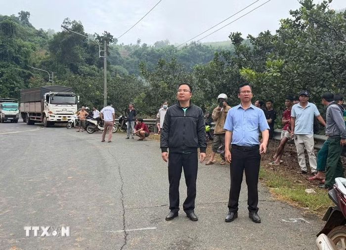 Chủ tịch Ủy ban Nhân dân xã Phước Sơn Trần Ngọc Công (bên phải) kiểm tra, chỉ đạo khắc phục sự cố đất tràn xuống mặt đường tỉnh 755B. (Ảnh: TTXVN phát)