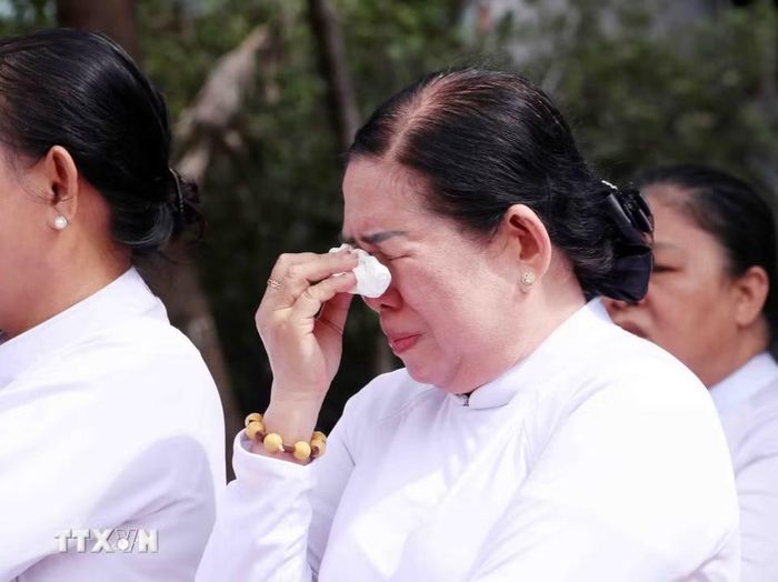 Nỗi xúc động của các tín hữu đạo Cao Đài trước anh linh các anh hùng liệt sỹ được quy tập tại Công viên Lê Thị Riêng. (Ảnh: Xuân Khu/TTXVN)