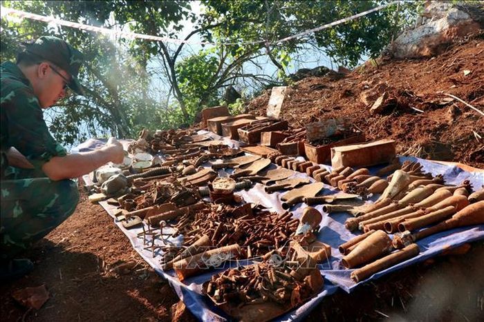 Vật liệu nổ và những di vật được cán bộ, chiến sĩ tìm thấy trong quá trình tìm kiếm hài cốt liệt sĩ trên điểm cao 685. Ảnh: Đức Thọ/TTXVN