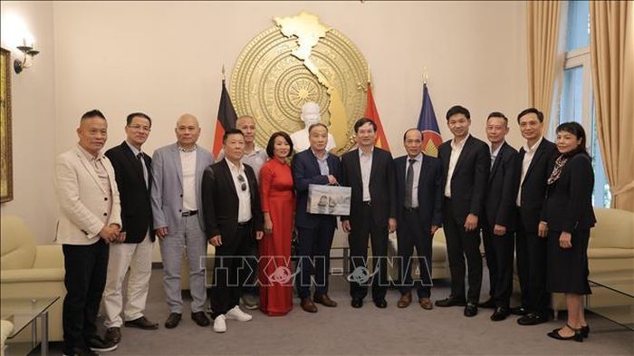 Phó Bí thư Thành uỷ Quảng Ninh Vũ Quyết Tiến tặng quà cho đại diện Hội đồng hương Quảng Ninh tại Đức. Ảnh: Thu Hằng/PV TTXVN tại Đức