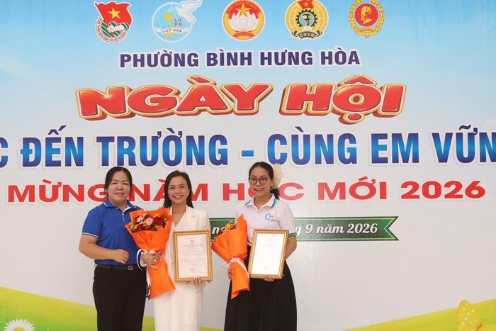 Bà Nguyễn Thanh Nguyệt, Chủ tịch Ủy ban MTTQ Việt Nam phường Bình Hưng Hòa (bìa trái), trao thư và hoa cảm ơn đến đại diện các đơn vị đã đồng hành cùng địa phương tổ chức ngày hội.