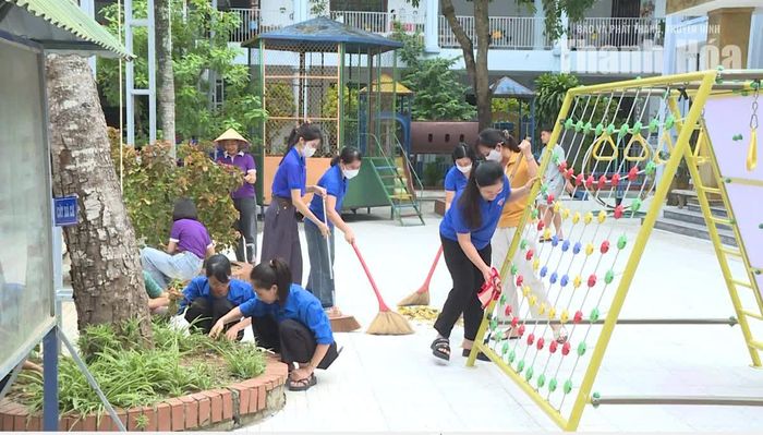 Cán bộ, giáo viên Trường Mầm non Quang Trung tham gia dọn dẹp vệ sinh khuôn viên trường lớp.