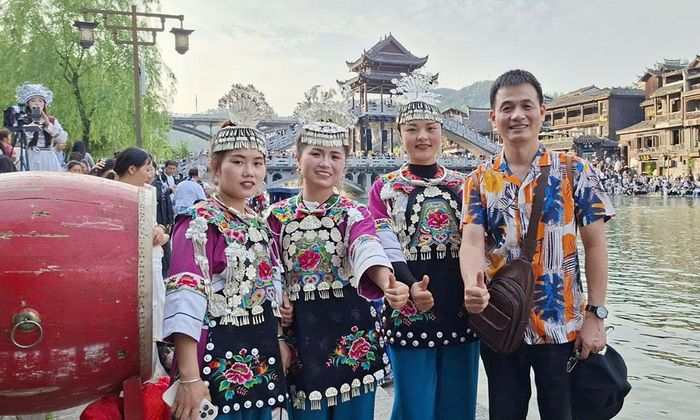  Những cô gái người Miêu biểu diễn múa trống và chụp ảnh lưu niệm với du khách. 