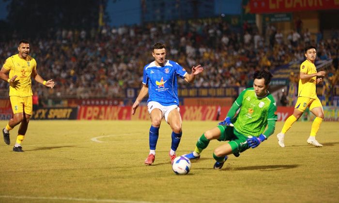  Tiền đạo David Fisher (áo xanh, quần trắng) của đội Bắc Ninh FC trong một tình huống làm khó thủ thành Sông Lam Nghệ An. 