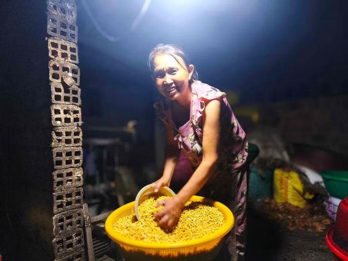 Để có thể làm được nhiều đậu hơn, nuôi 4 người con ăn học, từ 12 giờ đêm, bà Nguyễn Thị Đào đã phải xay đậu để bắt đầu mẻ đậu đầu tiên. Ảnh: Đ.N