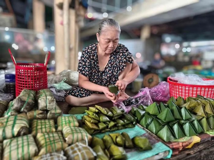 Bà Nguyễn Thị Sơn gói bánh tại chợ Phú Phong. Ảnh: Đ.N