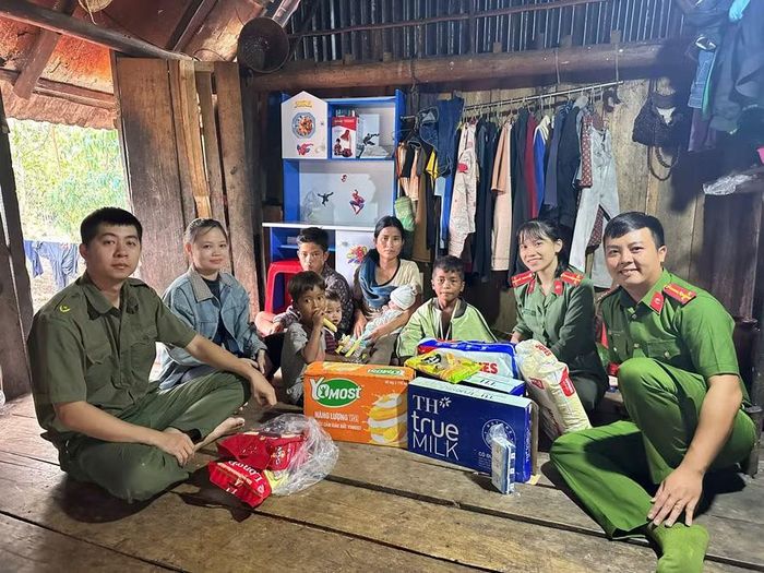 Cán bộ, chiến sĩ Công an xã Kbang đến nhà thăm hỏi, trao quà cho em Tý (thứ 3 từ phải sang) và gia đình. Ảnh: Phạm Dung