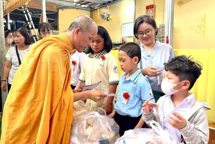 Đại đức Thích Minh Phú, trụ trì tịnh xá Ngọc Chánh trao quà đến các em học sinh có hoàn cảnh khó khăn