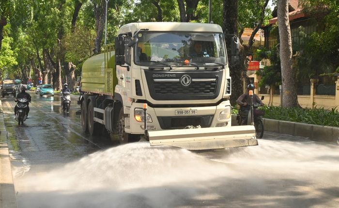 Tăng cường tưới nước rửa đường là biện pháp hạn chế bụi mịn phát tán vào không khí. Ảnh: Đức Duy