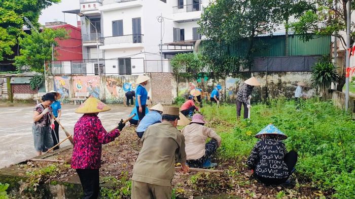 Vào cuối tuần, cán bộ cơ sở cùng người dân phường Lĩnh Nam tham gia dọn dẹp vệ sinh, duy trì vườn hoa trên các tuyến đường, khu vực công cộng như một thói quen. Ảnh: LN
