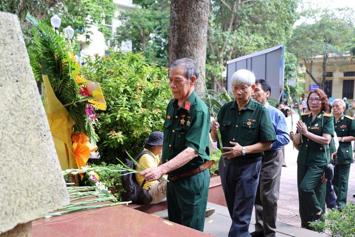 Các cựu sinh viên - chiến sĩ dâng hoa tại Đài tưởng niệm “Ngày lên đường bảo vệ Tổ quốc” trong khuôn viên Đại học Kinh tế Quốc dân. Ảnh: PV