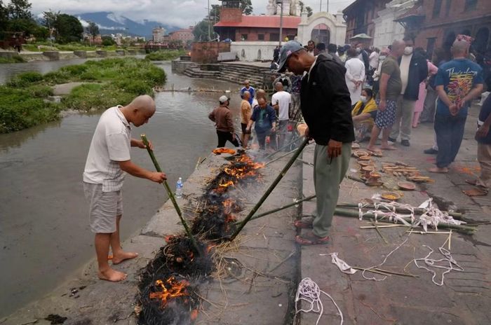 Một số người đang thực hiện những nghi lễ ở Kathmandu (Nepal) cho người thân mất tích trong lũ quét. Ảnh: AP Photo/ Dar Yasin.